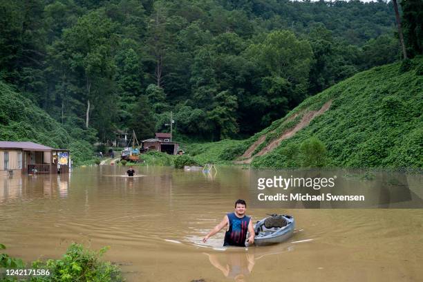 Lewis Ritchie, pulls a kayak through the water after delivering groceries to his father-in-law on July 28, 2022 outside Jackson, Kentucky. Storms...