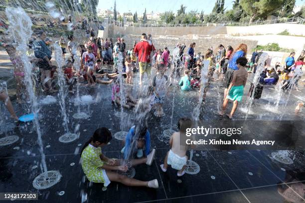 People spend time at a splash pad during a heatwave in Jerusalem, on July 28, 2022.