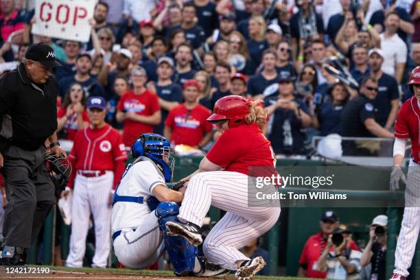 Catcher Sen. Chris Murphy, D-Conn., collides with Rep. Kat Cammack, R-Fla., as she was tagged out at home plate during the Congressional Baseball...