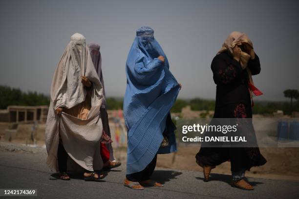 Afghan women walk alongside a road in Kandahar on July 29, 2022.