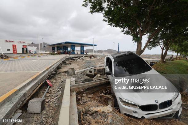 Car lies on the side of a road what was previously flooded in the UAE's Fujairah emirate following heavy rainfall on July 29, 2022.
