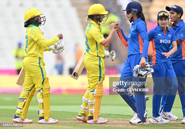 Australia's Alana King and Australia's Ash Gardner fist bump India's Yastika Bhatia after the women's Twenty20 cricket match between Australia and...