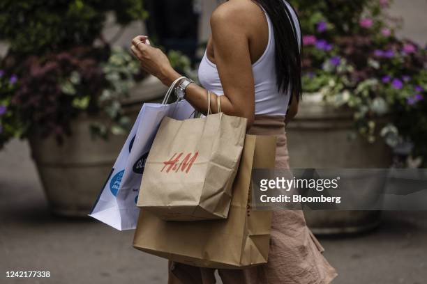 Shopper carries an H&M bag in New York, US, on Thursday, July 28, 2022. Consumer spending slowed to a 1% annualized growth rate from 1.8% for the...