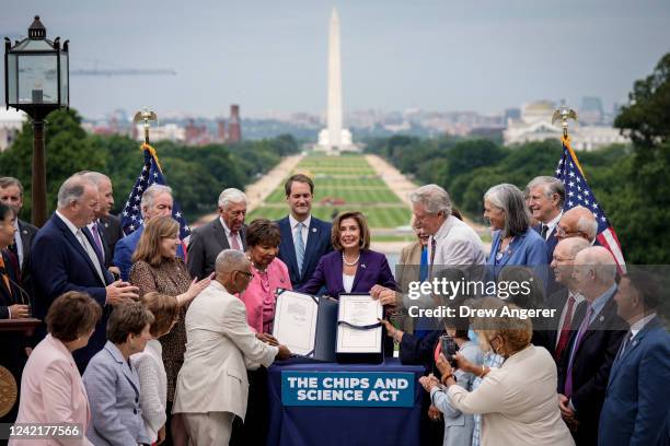 Speaker of the House Nancy Pelosi , alongside House Democrats, holds up the CHIPS For America Act during a bill enrollment ceremony outside the U.S....