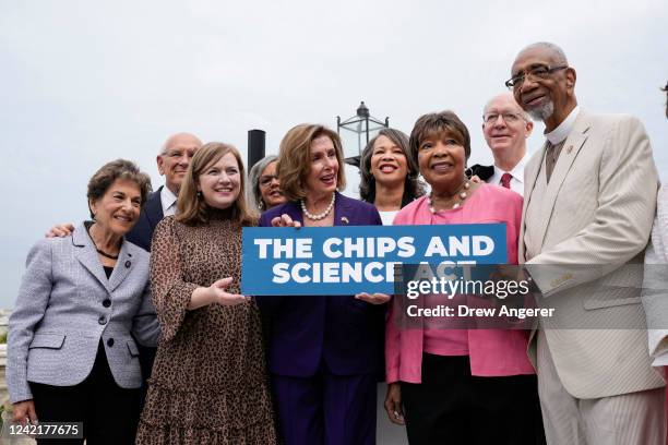 Surrounded by House Democrats, Speaker of the House Nancy Pelosi poses for a photo after signing the CHIPS For America Act during a bill enrollment...