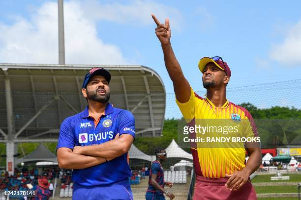 Nicholas Pooran of West Indies tosses the coin as Rohit Sharma of India watches during the 1st T20i match between West Indies and India at Brian Lara...