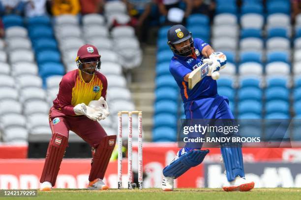 Rohit Sharma of India hits 4 and Nicholas Pooran of West Indies watch during the 1st T20i match between West Indies and India at Brian Lara Cricket...