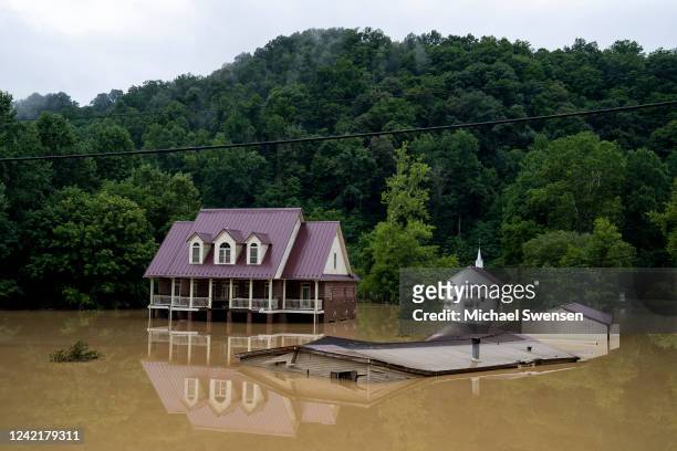 House is seen almost completely submerged off of the Bert T Combs Mountain Parkway on July 29, 2022 in Breathitt County, Kentucky. At least 16 people...