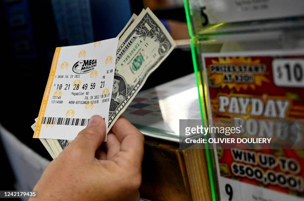 Person buys a Mega Millions lottery ticket at a store on July 29, 2022 in Arlington, Virginia. The jackpot for Friday's Mega Millions is now $1.1...