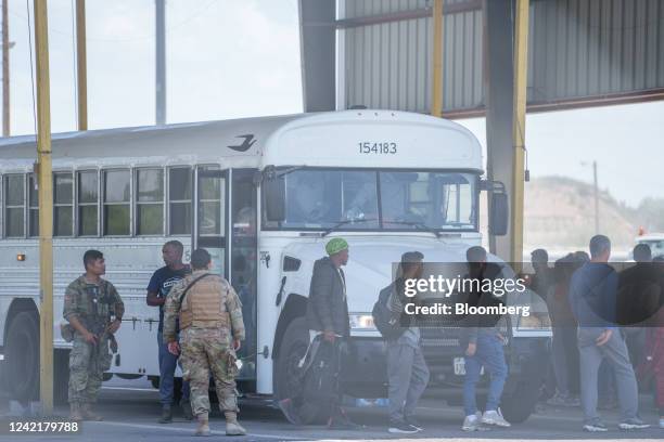 Members of the Texas National Guard direct migrants exiting from a Texas Department of Criminal Justice bus at the Eagle Pass Commercial Port of...