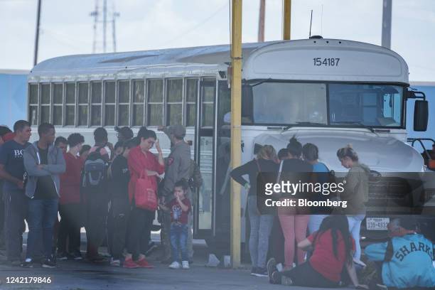 Migrants exit from a Texas Department of Criminal Justice bus at the Eagle Pass Commercial Port of Entry to wait for US Border Patrol transportation...