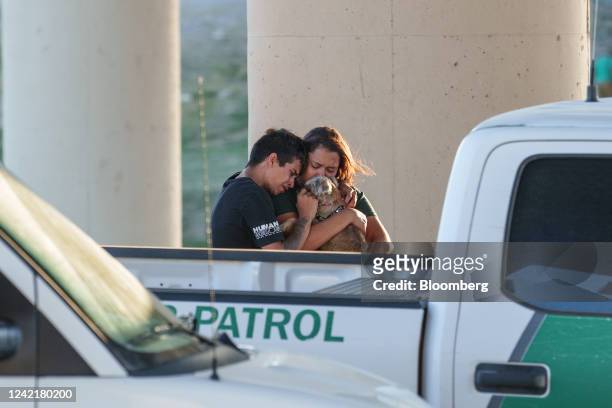 Migrants hug their dog goodbye before having to separate due to law enforcement orders after crossing the Rio Grande into the US in Eagle Pass,...