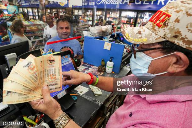 Hawthorne, CA Ronald Marine, right, sells $200 worth of Mega Millions lottery to Paul Sandoval, as jackpot tops $1 billion at Bluebird Liquor on...