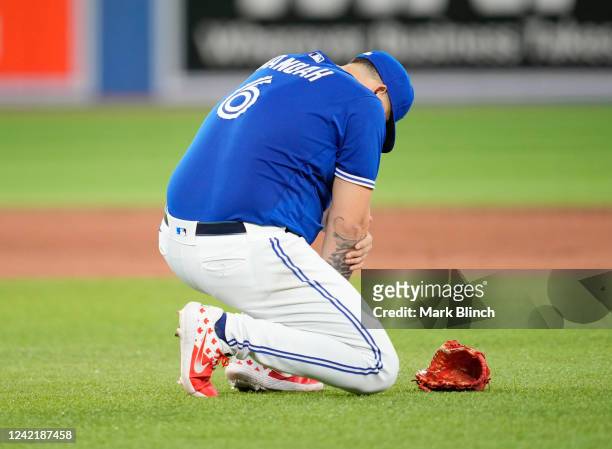 Alek Manoah of the Toronto Blue Jays holds his arm after being hit with a ball against the Detroit Tigers in the sixth inning during their MLB game...