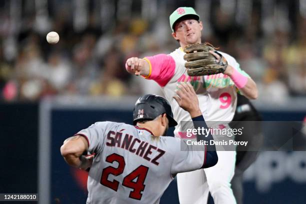 Jake Cronenworth of the San Diego Padres throws over Gary Sanchez of the Minnesota Twins as he turns a double play during the fifth inning of a...