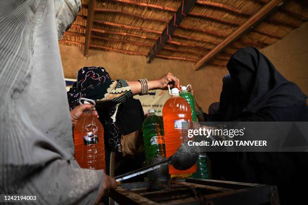 Afghan burqa-clad women work at a shampoo and soap factory in Kandahar on July 30, 2022.