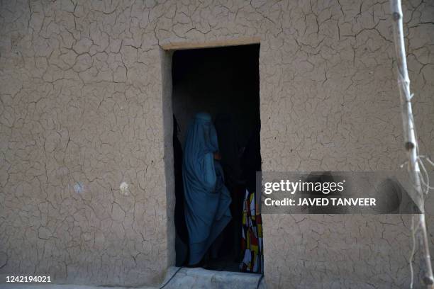 An Afghan burqa-clad woman stands inside a shampoo and soap factory in Kandahar on July 30, 2022.