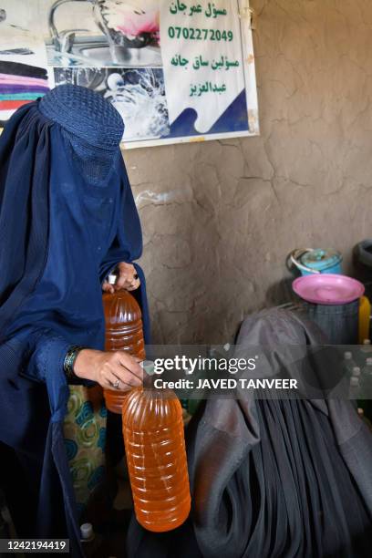 Afghan burqa-clad women work at a shampoo and soap factory in Kandahar on July 30, 2022.