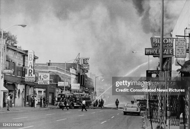 Firefighters tackle a blaze in Detroit, Michigan, during the 12th Street race riot, 27th July 1967.