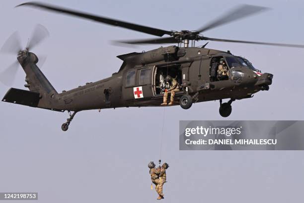 Army personnel of the 101st Airborne Division descend by rope from a Black Hawk helicopter during a demonstration drill at Mihail Kogalniceanu...