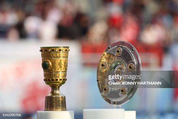 The German Cup and the German football League Bundesliga champion trophy are displayed ahead the German Supercup football match between RB Leipzig...