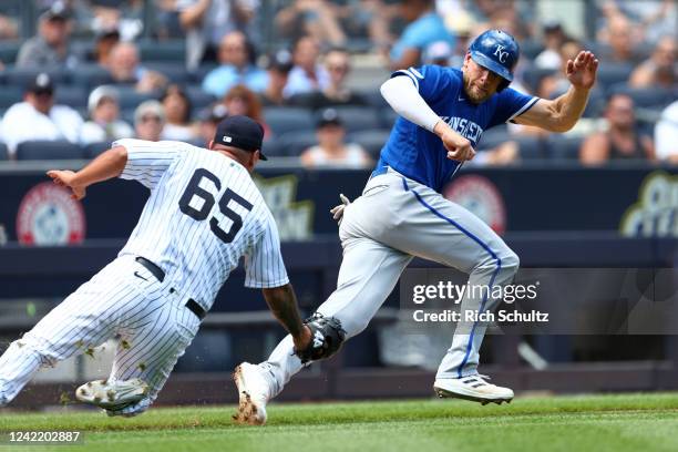 Pitcher Nestor Cortes of the New York Yankees attempts to tag out Hunter Dozier of the Kansas City Royals on a fielders choice hit by MJ Melendez...