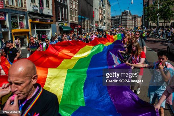 Group of people seen holding a huge rainbow flag. The annual equal rights demonstration for the global rainbow community took place in Amsterdam....
