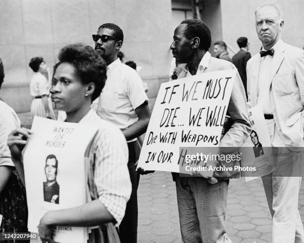 View of protesters, several with signs outside the UN Headquarters in New York, New York, July 23, 1964. They were protesting in the wake of the...