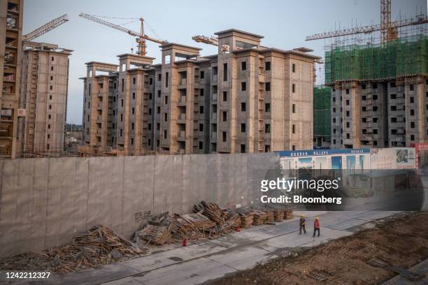 Workers leave the China Evergrande Group Royal Peak residential development under construction in Beijing, China, on Friday, July 29, 2022. A mild...