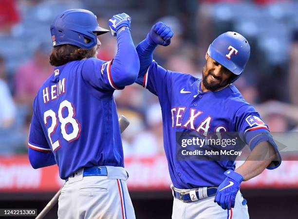 Jonah Heim of the Texas Rangers congratulates Marcus Semien of the Texas Rangers on his three-run home run in the fourth inning against the Los...