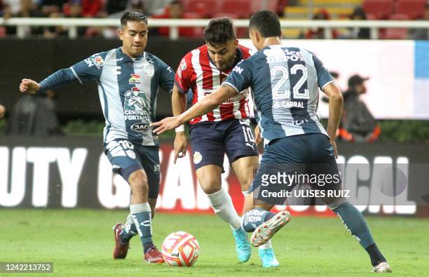 Alexis Vega of Guadalajara vies for the ball with Erick Sanchez and Gustavo Cabral of Pachuca, during their Mexican Apertura tournament football...