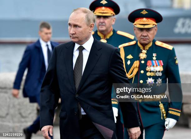 Russia's President Vladimir Putin , flanked by Russia's Defence Minister Sergei Shoigu , walks as he takes part in the main naval parade marking the...