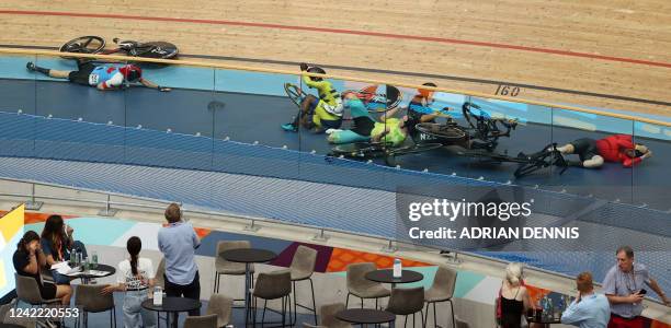 Riders lie on the track following a massive crash during the men's 15km scratch race qualifying round cycling event on day three of the Commonwealth...