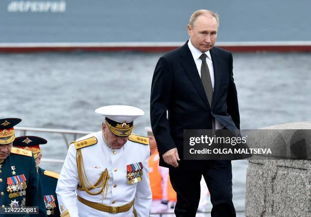 Russia's President Vladimir Putin walks with Commander-in-Chief of the Russian Navy, Admiral Nikolai Yevmenov as he takes part in the main naval...