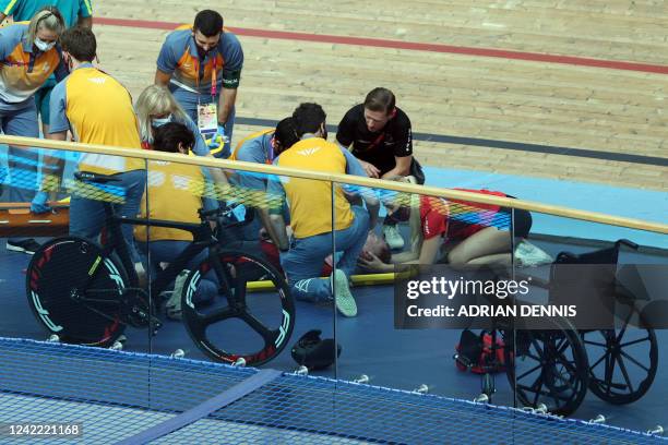 Medics tend to Isle of Man's Matthew Bostock as he lies on the track following a massive crash during the men's 15km scratch race qualifying round...