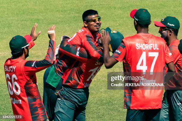 Bangladesh captain Quazi Nurul Hasan Sohan lifts his bowler Musaddek Hossain on getting five wickets in action during the second T20 cricket match...