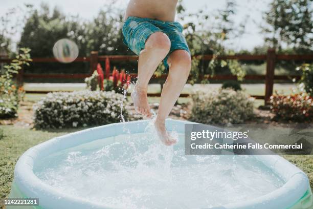 boy in paddling pool - planschbecken stock-fotos und bilder