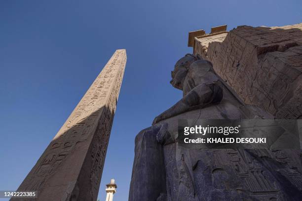 This picture shows a view of one of the Ramses II colossi and the remaining obelisk outside the Luxor Temple pylons in Egypt's southern city of the...