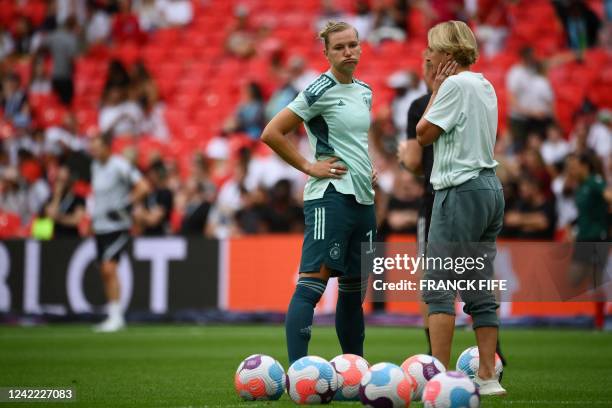 Germany's striker Alexandra Popp reacts as she speaks to Germany's head coach Martina Voss-Tecklenburg prior to the UEFA Women's Euro 2022 final...