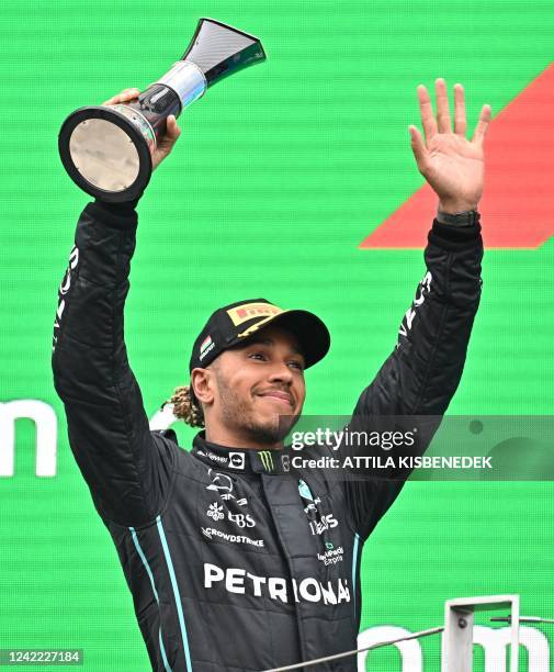 Mercedes' British driver Lewis Hamilton celebrates with the trophy on the podium after the Formula One Hungarian Grand Prix at the Hungaroring in...