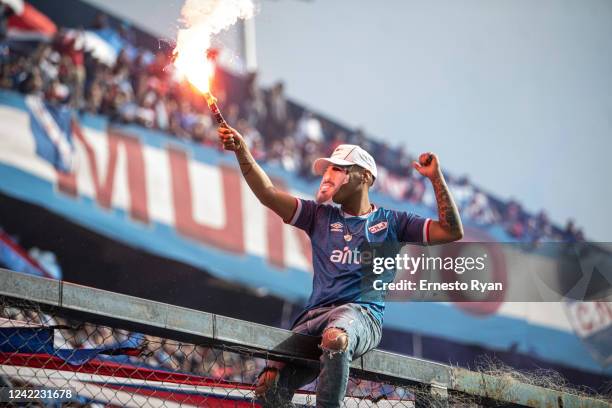 Fan with a flare wears a mask of Luis Suarez during the unveiling of the Uruguayan player Luis Suarez as the new player of Nacional at the Parque...