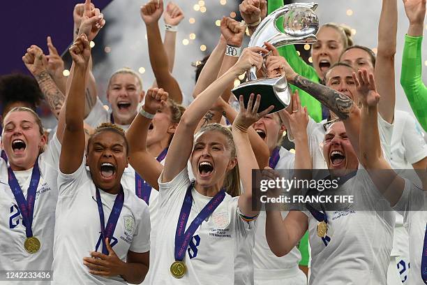 England's midfielder Leah Williamson and England's defender Millie Bright lift the trophy as England's players celebrate after their win in the UEFA...