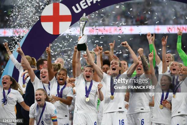 England's striker Ellen White and England's midfielder Jill Scott lift the trophy as England's players celebrate after their win in the UEFA Women's...