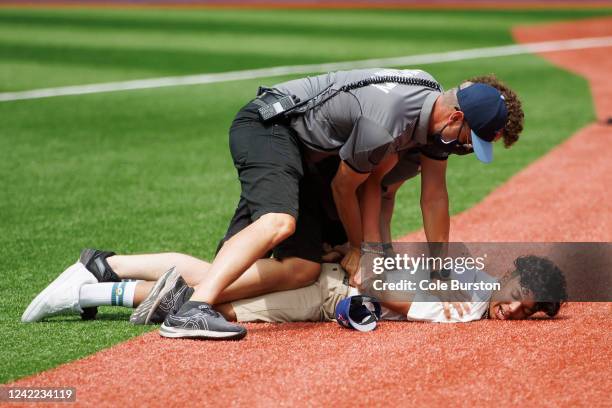 Security officers tackle a fan that ran onto the field during the ninth inning of the MLB game between the Toronto Blue Jays and the Detroit Tigers...