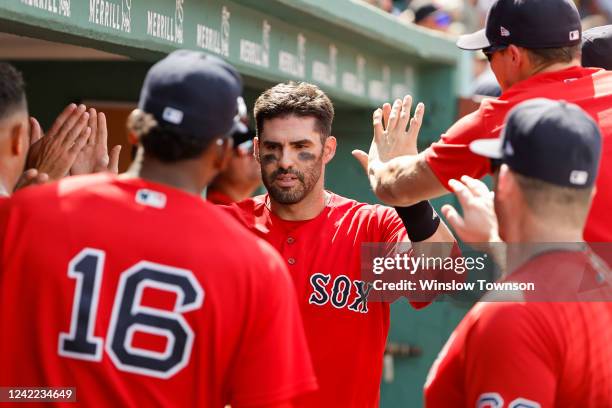 Martinez of the Boston Red Sox is congratulated by teammates after scoring against the Milwaukee Brewers during the fifth inning at Fenway Park on...