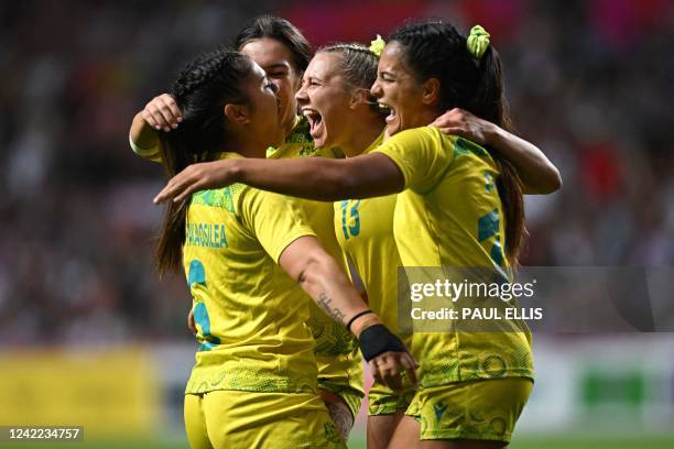 Australia's players celebrate their win at the end of the women's gold medal rugby sevens match between Australia and Fiji on day three of the...