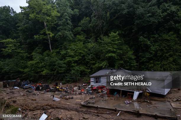 Debris surrounds a badly damaged home near Jackson, Kentucky, on July 31 after historic flooding swept through eastern Kentucky. - Rescuers in...