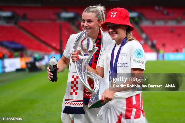 Ella Toone of England Women celebrates with the UEFA Womens Euro championship trophy and team-mate Lauren Hemp of England Women during the UEFA...