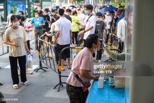 This photo taken on July 31, 2022 shows a health worker taking a swab sample from a woman to be tested for the Covid-19 coronavirus at a swab...