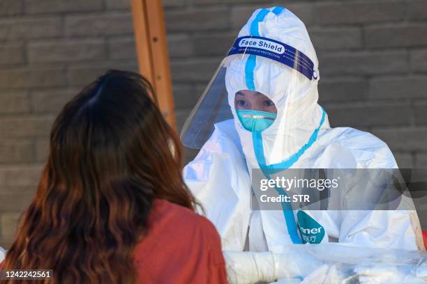 This photo taken on July 31, 2022 shows a health worker taking a swab sample from a woman to be tested for the Covid-19 coronavirus at a swab...